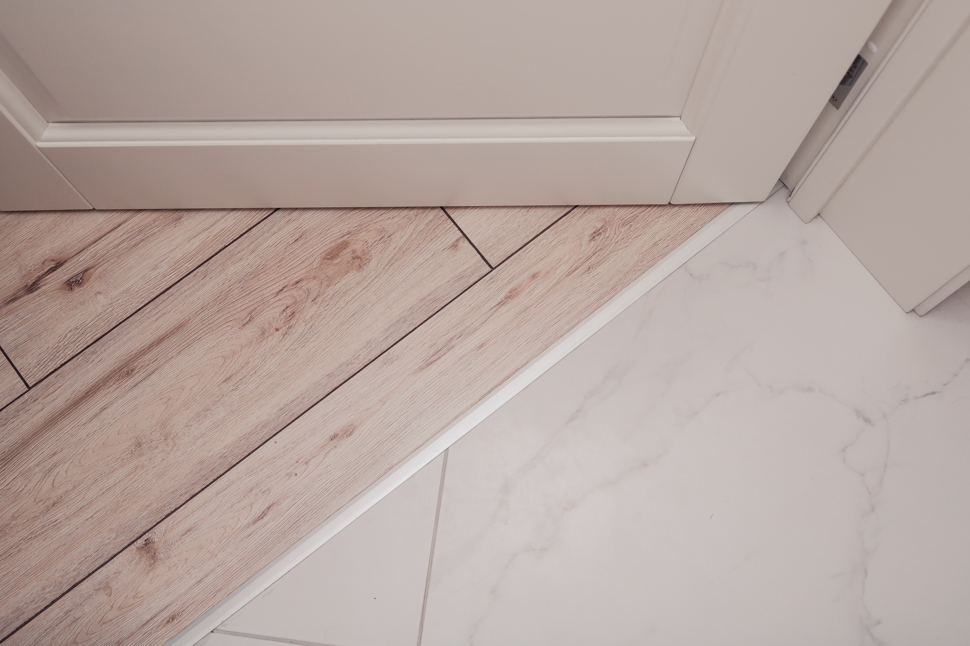 Aluminum threshold between ceramic tiles and parquet